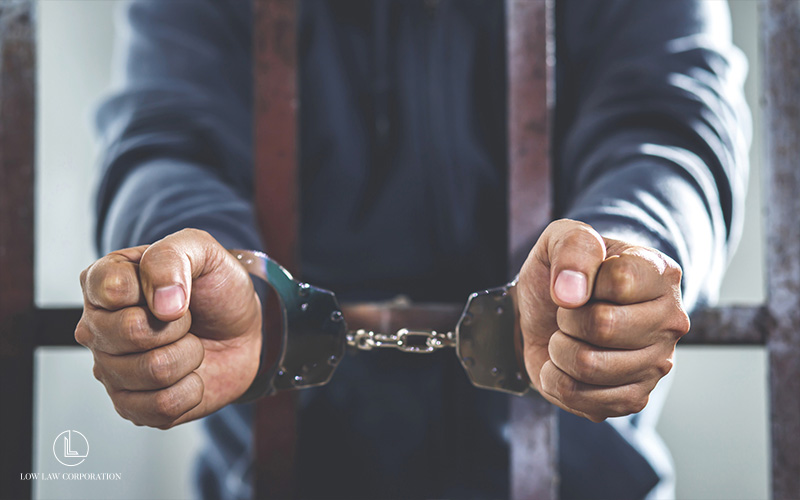 Man behind bars in handcuffs